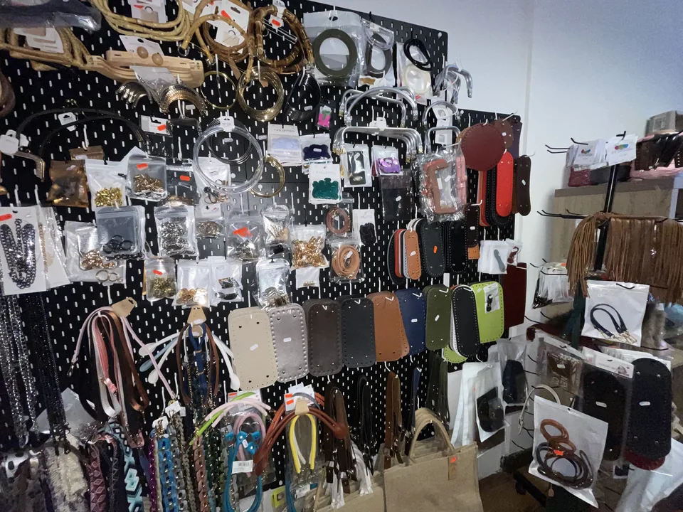 Parete con manici, tracolle, chiusure e accessori per borse