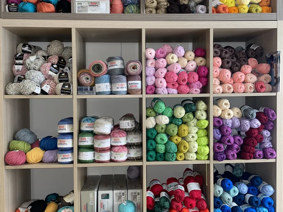 Scaffale con filati, lana e gomitoli colorati