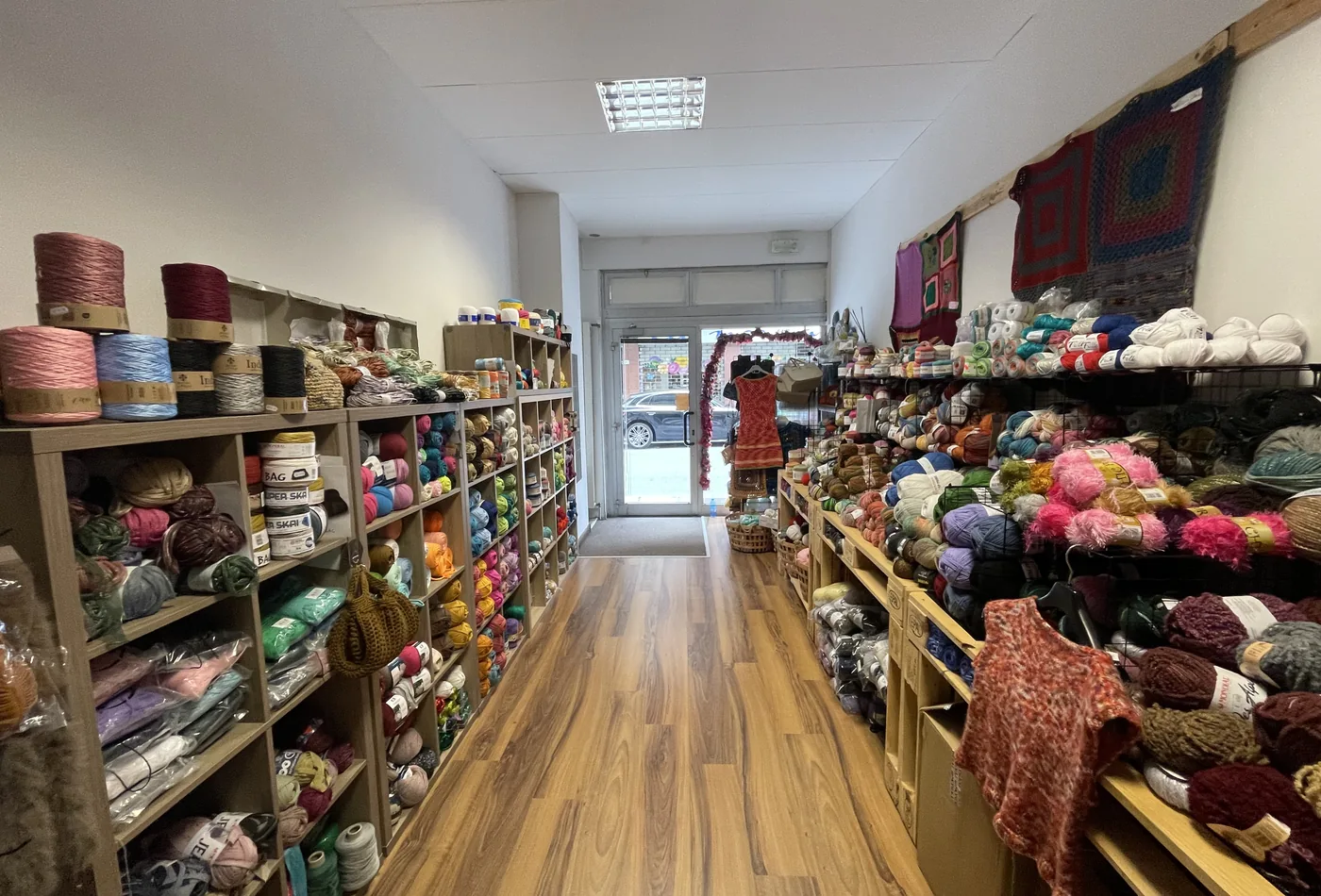 Interno della bottega Il Garbuglio con scaffali pieni di filati